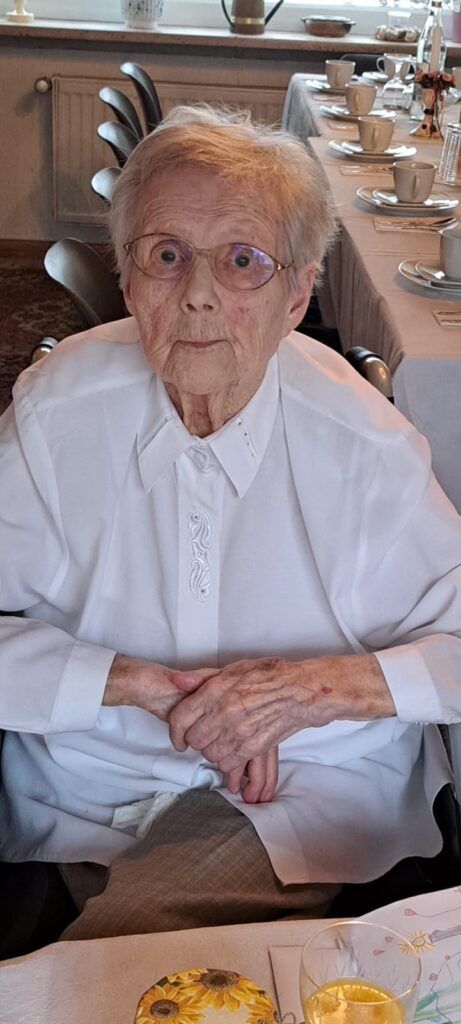 Foto von Käthe Schiffbauer an einer festlich gedeckten Kaffeetafel